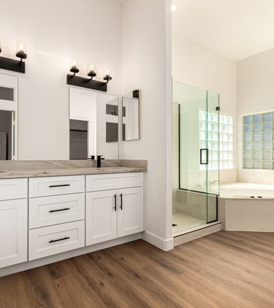 Elegant primary bathroom featuring dual sinks, modern cabinetry, and contemporary lighting. The Scottsdale bathroom connects to a spa-like shower and soaking tub for everyday comfort.