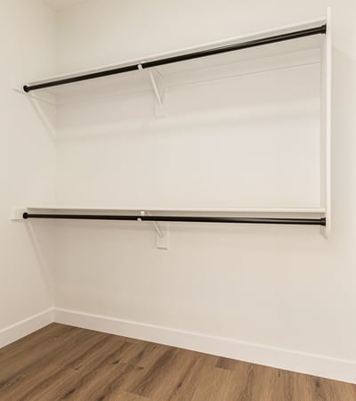 Generous walk-in closet with ample hanging rods and shelving for clothing storage. This Scottsdale closet provides convenient organization within the primary suite.