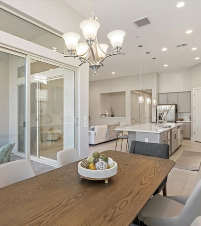 Dining area bathed in natural light, enhanced by tall windows and modern finishes, creating a warm and welcoming atmosphere.
