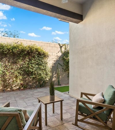 Shaded patio with paver flooring and cozy seating, offering a peaceful outdoor retreat ideal for relaxing or entertaining.