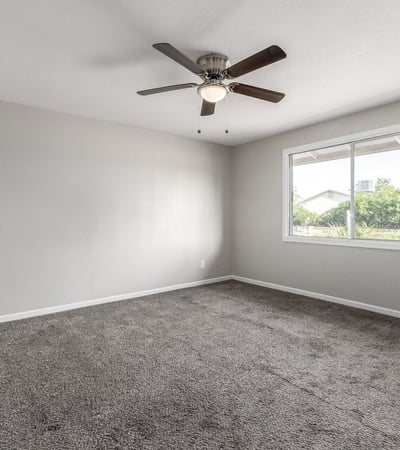 Guest bedroom with neutral paint, plush carpet, ceiling fan, and natural light ideal for guests, a nursery, or home office in Phoenix.