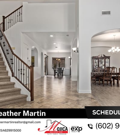 This grand entry showcases vaulted ceilings, tile flooring, and a staircase with iron accents. The open floor plan connects seamlessly to the formal dining area, ideal for entertaining.