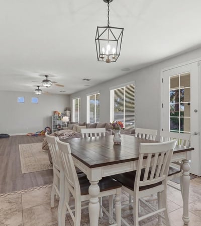 Dining area with elegant pendant lighting and French doors providing access to the backyard pool and outdoor living area.
