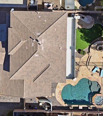 Direct overhead aerial showcasing the backyard design with pool, spa, patio seating areas, and landscaped yard perfect for outdoor entertaining in Queen Creek.