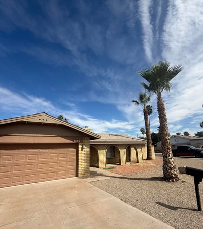 Front entry and garage view highlighting the arched porch architecture and spacious driveway. This Glendale property features a practical layout with attractive curb appeal.