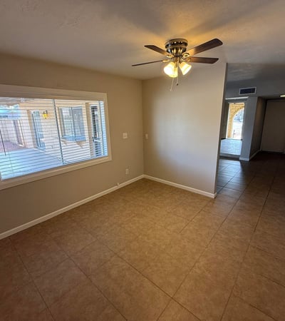 Bedroom with sliding doors opening directly to the backyard patio and pool area. Natural light and tile flooring enhance the bright feel of the room.