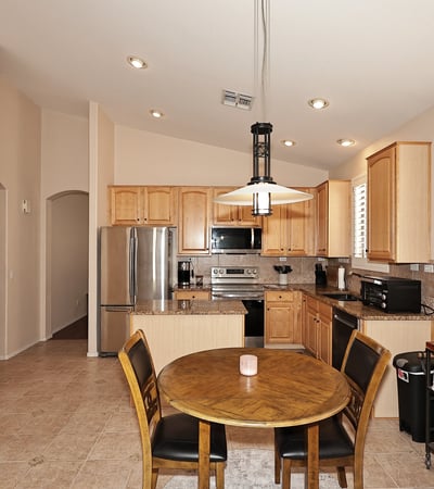 Open-concept kitchen and dining space with granite counters and plantation shutters. This Phoenix home is designed for easy entertaining and daily living.