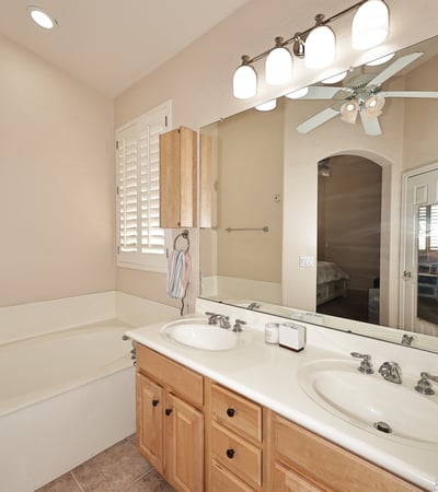 Primary bath with dual vanities, soaking tub, and abundant counter space. This Phoenix home features practical design, natural light, and comfortable finishes.