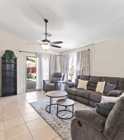 Spacious family room with sliding door leading to the backyard, ceiling fan, and open design for seamless indoor-outdoor living.