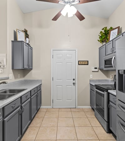 Stylish kitchen showcasing stainless steel appliances, generous cabinet storage, and functional layout open to main living areas.