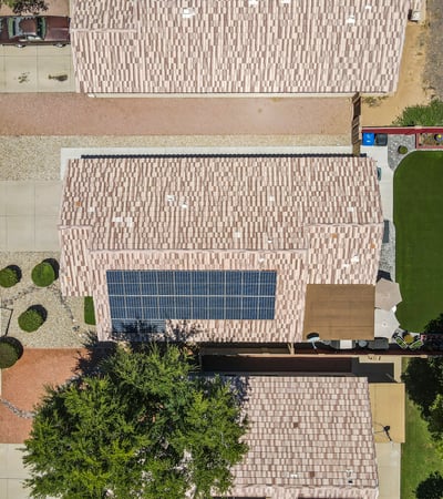 Top-down view displaying the home s footprint, solar system, and spacious backyard with turf and patio areas in Surprise.