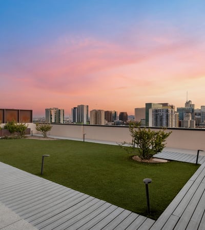 Landscaped rooftop area with open lawn and skyline views, offering a peaceful outdoor setting in this modern Phoenix property.