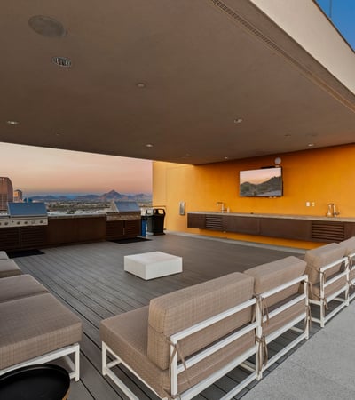 Stylish rooftop entertainment area featuring built-in grills, seating, and open-air design, ideal for hosting in Phoenix.