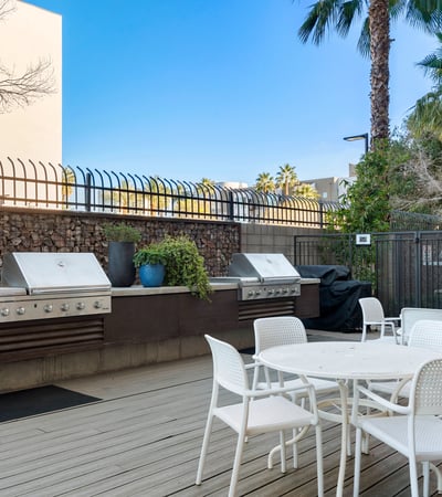 Outdoor BBQ area with multiple grills, seating, and modern finishes, creating a perfect gathering space in Phoenix.