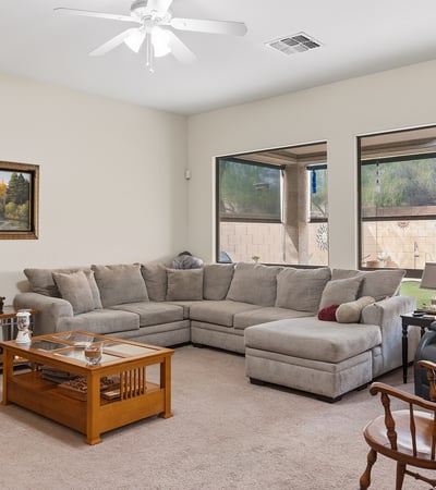 Bright living room with large windows, open layout, and comfortable design, ideal for both entertaining and relaxing in this Phoenix property.