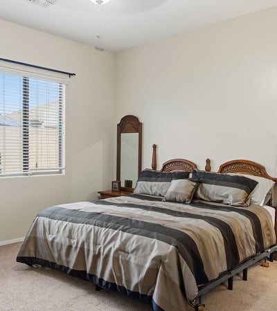 Inviting primary bedroom with large window, soft natural light, and neutral finishes, offering a peaceful retreat in this Phoenix home.