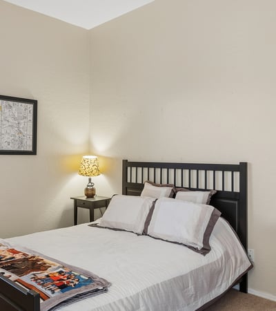 Bright secondary bedroom with window views, neutral tones, and flexible use for guests or family in this Phoenix home.