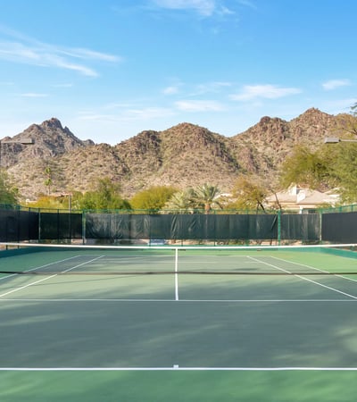 Community tennis court set against scenic mountain views, offering recreational amenities in this Phoenix neighborhood.
