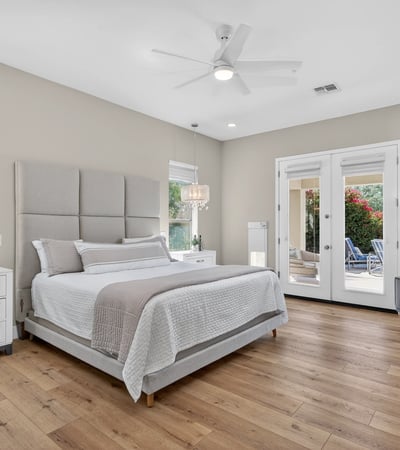 Beautiful Scottsdale primary suite with direct outdoor access, wood flooring, and modern ceiling fan, offering a peaceful and private retreat.
