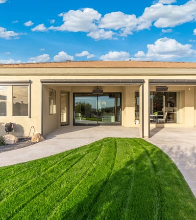 Scottsdale outdoor space with covered patio, green lawn, and sliding glass doors, creating seamless indoor-outdoor living.