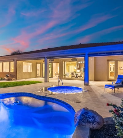 Scottsdale outdoor space with illuminated spa, covered patio, and poolside seating, ideal for relaxing evenings.
