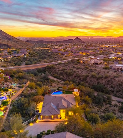 Scottsdale aerial highlighting nearby mountains, desert landscape, and surrounding homes in a scenic environment.