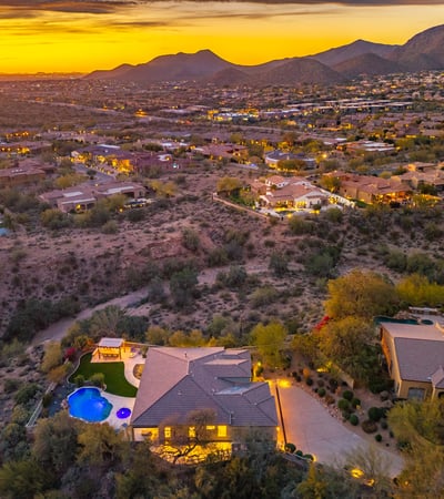 Scottsdale aerial capturing expansive desert views, surrounding homes, and vibrant sunset colors.