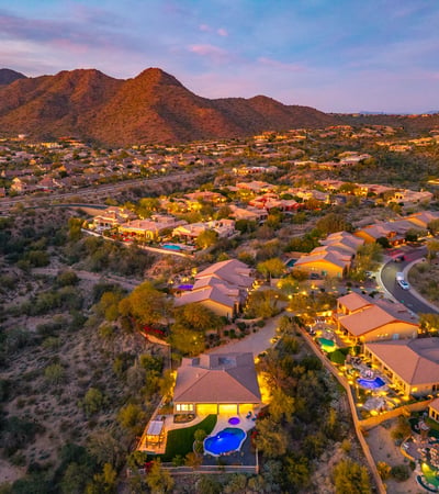 Scottsdale aerial view of the community with desert surroundings, mountain views, and glowing evening ambiance.