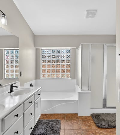 Bright primary bathroom with dual vanities, soaking tub, and walk-in shower. Functional layout offers everyday comfort in this Casa Grande property.