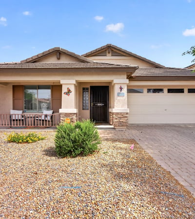 Attractive exterior with covered porch, desert landscaping, and attached garage. Clean curb appeal defines this Casa Grande property.