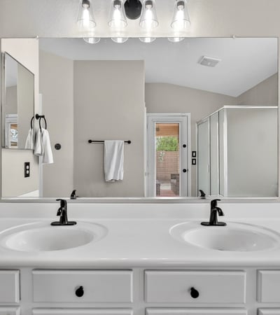 Spacious primary bathroom with dual vanities and modern fixtures. Functional layout enhances everyday convenience in Casa Grande.