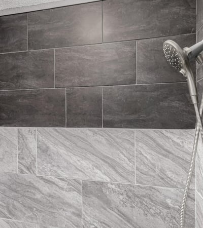 Modern shower with dual shower heads and custom tile detail. This Sun City home provides spa-inspired upgrades and elegant finishes.
