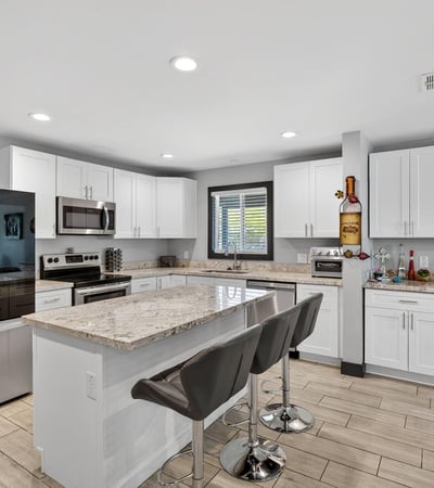 Renovated kitchen featuring granite countertops, stainless appliances, and a large island, designed for both everyday use and entertaining.