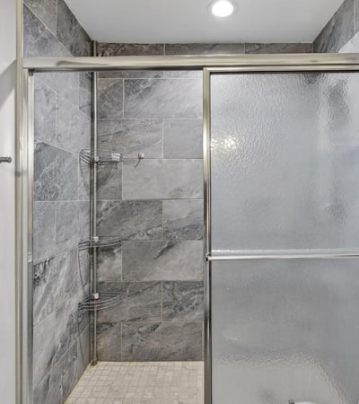 Contemporary walk-in shower with glass enclosure and upgraded tile, enhancing the home's modern appeal.