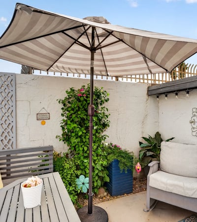 Relax in a private Scottsdale patio featuring shaded seating, decorative accents, and low-maintenance landscaping ideal for outdoor living and entertaining.