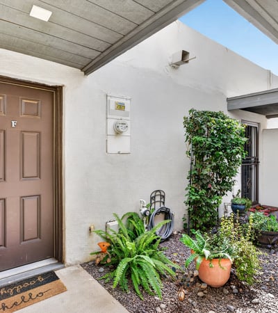 Covered front entry with desert landscaping and greenery creates a warm welcome to this Scottsdale townhome with added privacy and charm.