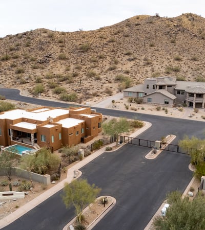 Secure gated entrance welcomes residents into an upscale hillside neighborhood surrounded by luxury custom homes and scenic desert landscapes near South Mountain Preserve.