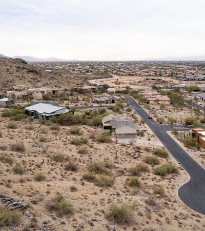 Exceptional aerial perspective showcasing the property s elevated setting among scenic desert terrain and luxury homes. Build your dream residence surrounded by breathtaking Phoenix mountain views.