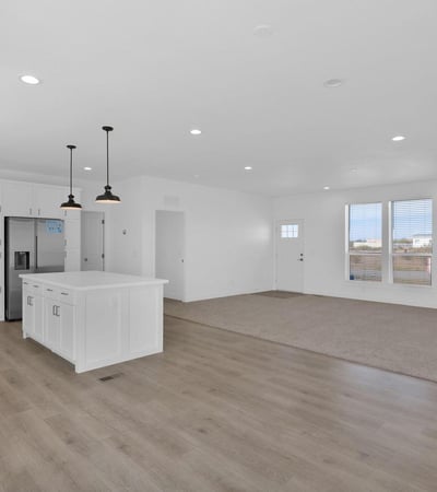 Large living and dining area flowing effortlessly into the kitchen, creating a versatile space for everyday living. The spacious floor plan highlights the home's modern design and comfortable functionality.