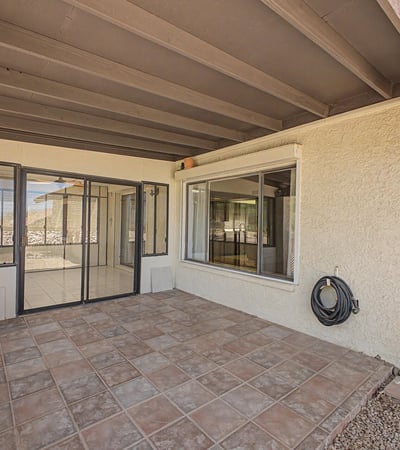 This covered patio provides a comfortable outdoor gathering space with direct access to the enclosed Arizona room. The low-maintenance design enhances everyday enjoyment and outdoor entertaining possibilities.