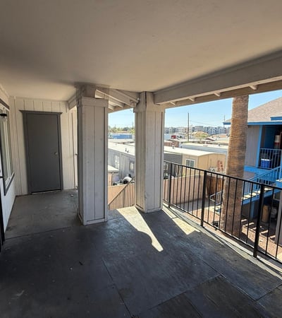 Second-level covered walkway with railings and open views overlooking the community grounds. This shaded exterior space enhances accessibility while contributing to the property's welcoming atmosphere.