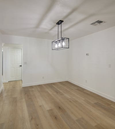 This open dining area offers flexible space, updated flooring, modern lighting, and seamless access to the remodeled kitchen for effortless entertaining.