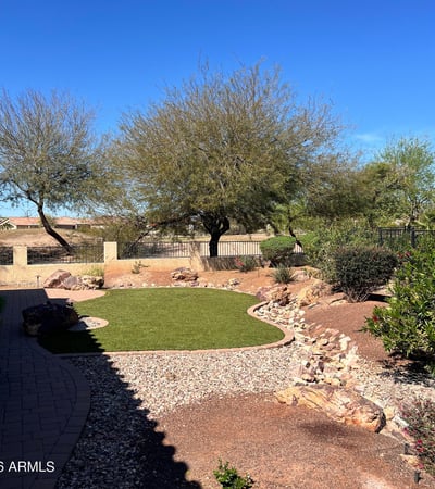 Enjoy peaceful golf course living with beautifully maintained artificial turf, mature shade trees, decorative desert landscaping, and picturesque White Tank Mountain views. This private outdoor space offers exceptional beauty with minimal upkeep.