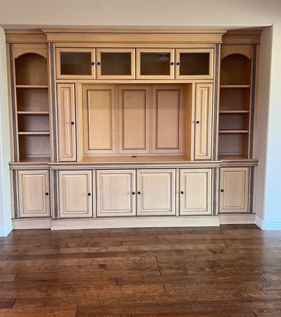 Beautiful custom entertainment wall featuring rich built-in cabinetry, open display shelves, enclosed storage, and premium craftsmanship that adds elegance and functionality to the great room.
