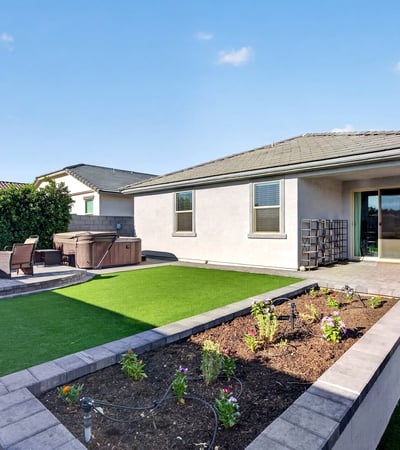 Professionally finished with synthetic grass, raised planter beds, paver patios, and covered outdoor living, this backyard provides the perfect blend of beauty, comfort, and low-maintenance landscaping.