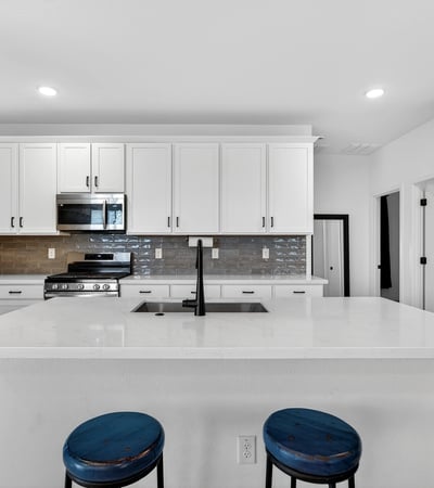 The expansive kitchen island provides casual seating, extra storage, quartz countertops, and an ideal gathering place while maintaining an open connection to the home's living areas.