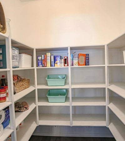 Oversized walk-in pantry with extensive built-in shelving and abundant storage, providing excellent organization for food, cookware, and household essentials just steps from the updated kitchen.