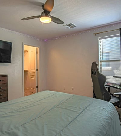 Spacious bedroom featuring soft carpeting, ceiling fan, and abundant natural light. This flexible room adapts easily as a guest room, teen suite, or dedicated workspace.