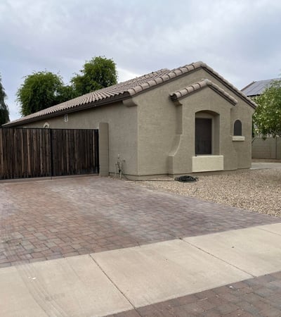 Beautiful front fa ade with a covered entry, attached garage, and mature landscaping welcomes you home with timeless curb appeal and easy-maintenance desert landscaping.