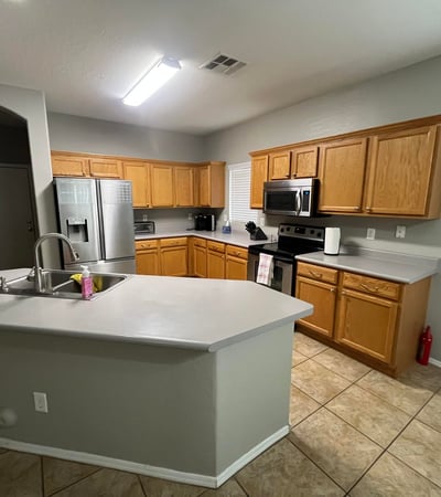 Spacious kitchen showcases oak cabinets, stainless steel appliances, a center island with breakfast bar, and an open layout ideal for cooking, entertaining, and gathering with family.